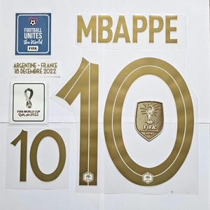May include: Gold-colored Mbappe name and number 10 decals, along with FIFA World Cup and event logos. Includes text: "FOOTBALL UNITES the World", "ARGENTINE - FRANCE 18 DECEMBRE 2022", and "FIFA WORLD CUP Qatar2022".