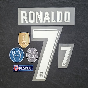 May include: A collection of white and gray heat transfer patches for a jersey. Includes the name "RONALDO", the number "7", and various team and tournament emblems. The patches are on a black background.