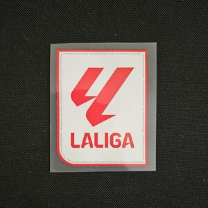 May include: A white patch with a red logo of a stylized letter "L" with the text "LALIGA" below it.
