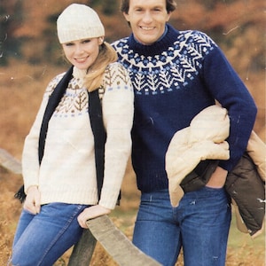 Peut inclure: Un couple portant des pulls assortis à motifs blancs et bleus. La femme porte un bonnet blanc en tricot et l'homme porte un pull bleu à motifs blancs et bleus. Ils portent tous les deux un jean bleu.