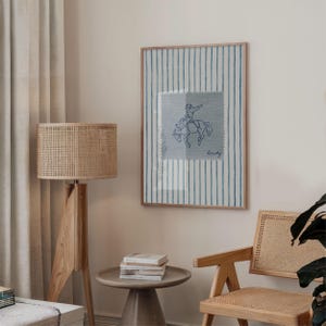 Add a bold statement to your space with this vintage striped rodeo print. Featuring retro blue and white stripes with a rustic western vibe, this cowboy poster is perfect for adding western bedroom wall art flair. The charming retro horse print blends seamlessly into rustic mid century modern home decor styles and makes a cute accent for dorm decor. Ideal for rodeo lovers, cowboy fans, and anyone who loves unique vintage western style.