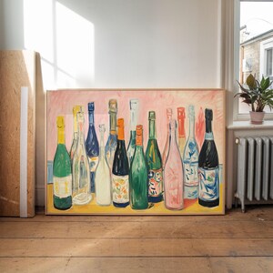 May include: A framed painting featuring a collection of wine and champagne bottles. The bottles are depicted in various colors, including green, blue, and pink, against a pink background. The painting is displayed on a wooden floor.