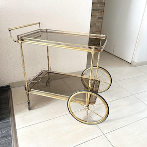 Luxe serveerwagen met getinte glazen bovenkant messing Franse barwagen Hollywood Regency bijzettafel Maison Bagués vintage goud