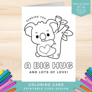 Puede incluir: Diseño de tarjeta para colorear en blanco y negro con un koala abrazando un corazón, con el texto "SENDING YOU A BIG HUG AND LOTS OF LOVE!". La tarjeta está diseñada para imprimir en casa.