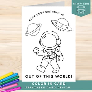 May include: A black and white printable birthday card design featuring an astronaut, a planet with rings, and a flying saucer. The text reads "Hope your birthday is out of this world!" and "Color in card, printable card design."