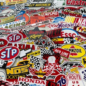 May include: A collection of colourful, vintage racing stickers. The stickers feature various logos, including "STP", "Red Line", "Snap-on Racing", "NOS", "Rockstar", "Hoosier", "NISMO", "Castrol", "Wests", "Formula", "K&N", "Red Line", "Pennzoil", "Monkey Trip", "Route US", and "Honda Racing".