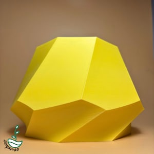 以下が含まれることがあります： 鮮やかな黄色で、幾何学的な多面体の彫刻。滑らかでマットな仕上がりで、複雑な多面体の形をしています。彫刻はニュートラルな背景に配置され、その形と色が際立っています。