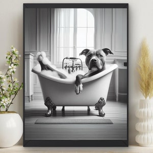 May include: A black and white photo of a dog relaxing in a white bathtub with bubbles. The dog is looking directly at the camera. The photo is framed in a black frame.