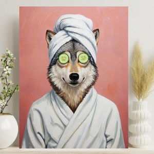 Puede incluir: Impresión en lienzo de un lobo con una bata de spa blanca y una toalla, con rodajas de pepino sobre los ojos. El fondo es de color rosa. La obra de arte se exhibe en una estantería de madera con jarrones decorativos y flores.