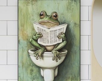 May include: A framed art print depicts a green frog sitting on a toilet, engrossed in reading a newspaper. The frog has large, expressive eyes and is set against a textured green background. The artwork is displayed in a bathroom setting.