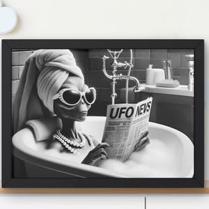 May include: A black and white photo of an alien wearing sunglasses and a towel on their head, relaxing in a bathtub and reading a newspaper titled "UFO NEWS".