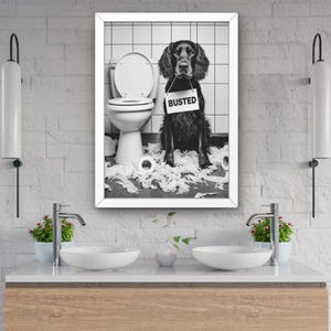 以下が含まれることがあります： トイレに座って、周りにトイレットペーパーが散らばっている犬の白黒写真。犬は「バステッド」と書かれた看板をつけています。