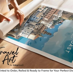 a person's hands rolling up a large poster or canvas that displays a colorful illustration of a coastal town. The poster is titled "Amalfi Coast Italy" and is described as a travel art piece. The image is printed to order, rolled, and ready to frame for your perfect display.
