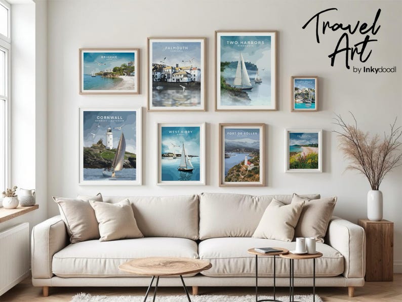 a cozy living room with a white sofa and a coffee table, adorned with framed pictures of coastal towns and sailboats. The pictures are arranged on the wall, creating a visually appealing display.