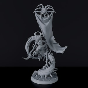 May include: A gray 3D printed miniature of a female figure riding a scorpion with a spider holding a banner above her head.