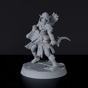 May include: A gray plastic miniature figurine of an elf archer wearing a hooded cloak and holding a bow and arrow. The figurine is standing on a circular base.