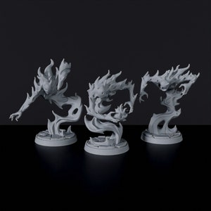 Könnte beinhalten: Drei graue, flammenförmige Figuren mit einem gespenstischen Aussehen. Jede Figur steht auf einem runden Sockel.