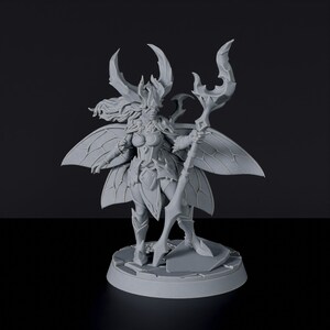 May include: A gray, detailed miniature figurine of a female figure with butterfly wings, antler-like headwear, and a staff. The figure is standing on a circular base.