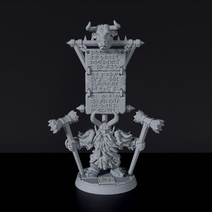 May include: A gray 3D printed miniature of a dwarf holding two hammers and standing in front of a sign with a bull's head and text in an unknown language.