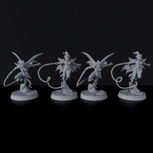 May include: Four gray painted miniature figurines of female figures with wings and tails, each holding a whip, standing on circular bases.