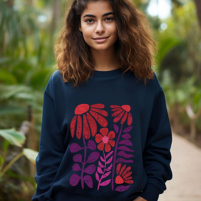 May include: A navy blue sweatshirt with a colorful floral print. The print features red, pink, and purple flowers with green stems and leaves.