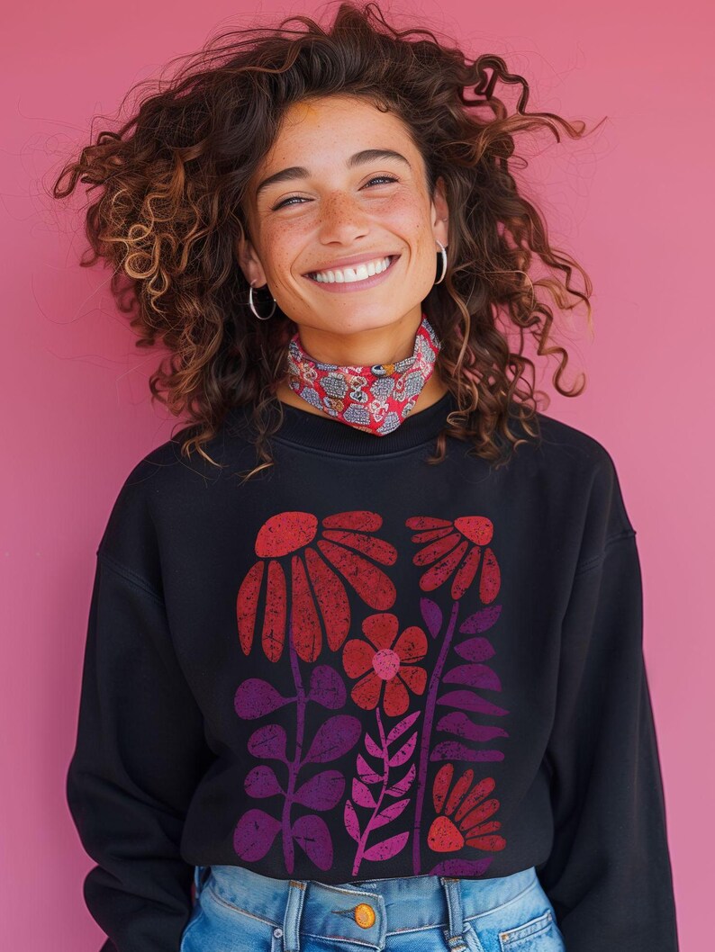 May include: A black sweatshirt with a colorful floral print. The flowers are red, pink, and purple and have a vintage, retro style.