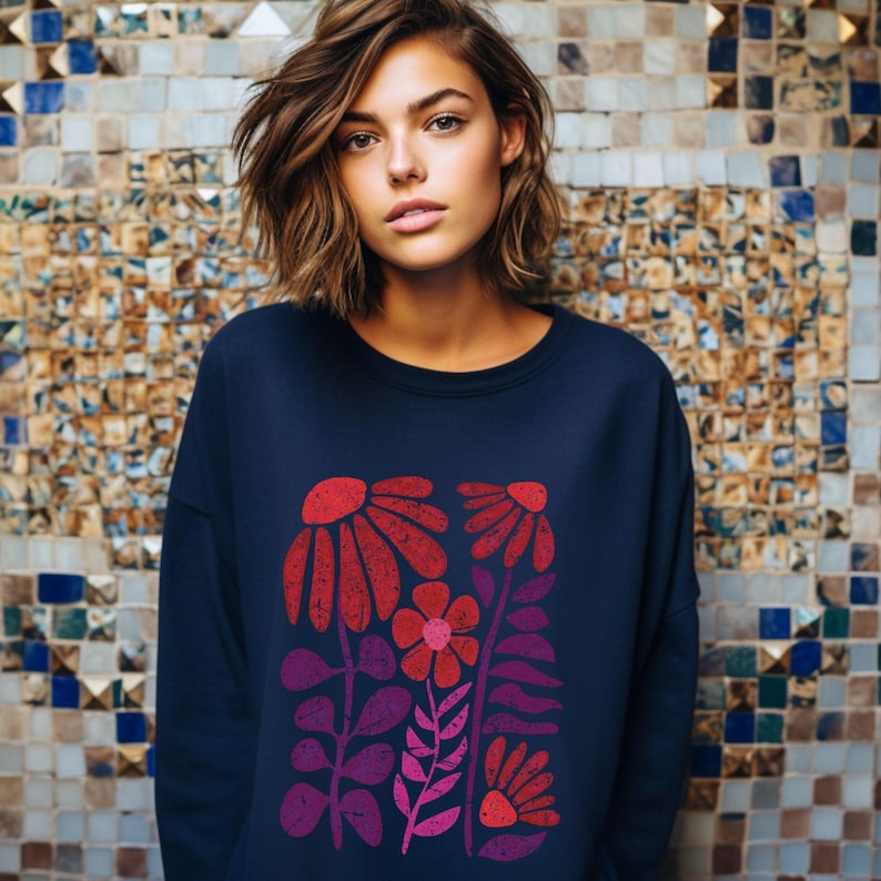 May include: A navy blue sweatshirt with a colorful floral print. The print features red, pink, and purple flowers and leaves.