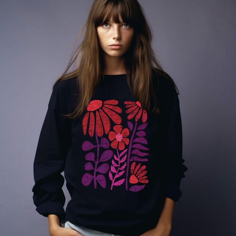 May include: A black long-sleeved sweatshirt with a colorful floral print. The flowers are red, pink, and purple and have a retro style.