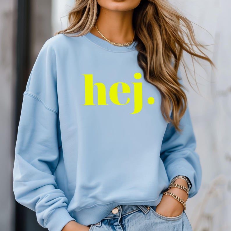 May include: A light blue sweatshirt with a yellow "hej" graphic print.