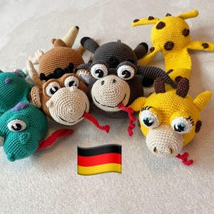May include: Five crocheted stuffed animals in the shape of a giraffe, a monkey, a crocodile, a bull, and a snake. The animals are all different colors and have embroidered eyes and mouths.