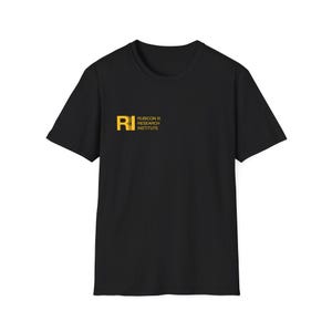 以下が含まれることがあります： 「Rubicon III Research Institute」とスタイリッシュなフォントで「RI」の文字が書かれた黄色いロゴがついた黒いTシャツです。