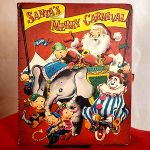 May include: Vintage Christmas-themed book cover with the text "Santa's Merry Carnival." The illustration features Santa Claus, an elephant, a clown riding a tricycle, and several elf-like characters. The background is red with yellow banners.