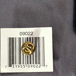May include: A gold-colored lapel pin with a decorative design. The pin is round and has a butterfly clutch back. The image also shows a white label with the number "09022" and a barcode.