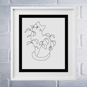 May include: Black and white line art cross stitch pattern of a cat sitting in a plant. The cat has a red heart on its nose.