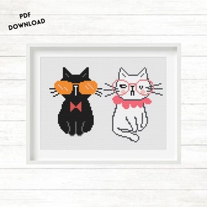 Puede incluir: Patrón de punto de cruz con dos gatos que llevan gafas. El gato negro lleva gafas de sol y una pajarita roja. El gato blanco lleva gafas rosas y un collar rosa.