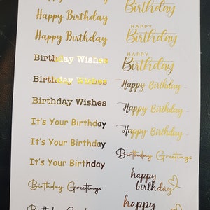 May include: A sheet of gold and copper foil stickers with various birthday greetings. The stickers include phrases like "Happy Birthday", "Birthday Wishes", "It's Your Birthday", and "Birthday Greetings".
