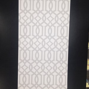 May include: White wallpaper with a repeating geometric pattern of interlocking circles and ovals.