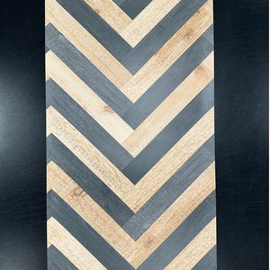 Puede incluir: Un papel tapiz con patrón de chevron con rayas alternas de madera negra y marrón.