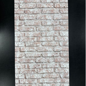 May include: Whitewashed brick wall backdrop with a distressed, vintage look. The bricks are a light brown colour with white paint chipping off, creating a rustic and weathered aesthetic.