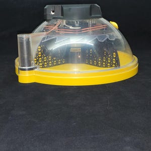Puede incluir: Una trampa para insectos amarilla y negra con una c&uacute;pula de pl&aacute;stico transparente. La trampa tiene una base negra y una c&uacute;pula de pl&aacute;stico transparente con una malla negra en el interior.