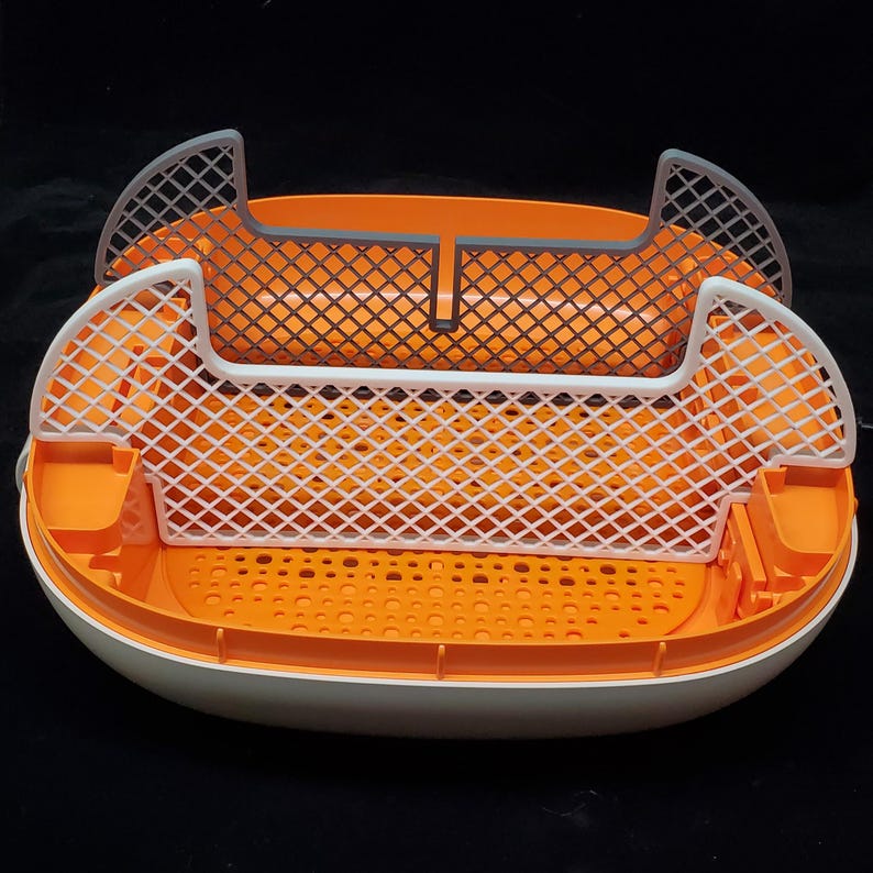 May include: A white and orange plastic litter box with two removable, gray and white mesh trays. The trays are designed to separate waste from litter.