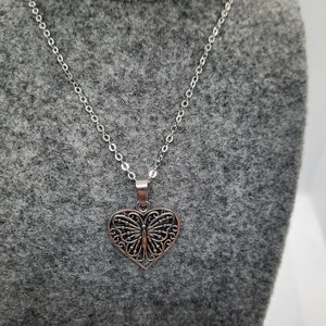 Butterfly heart pendent on delicate silver colored chain.