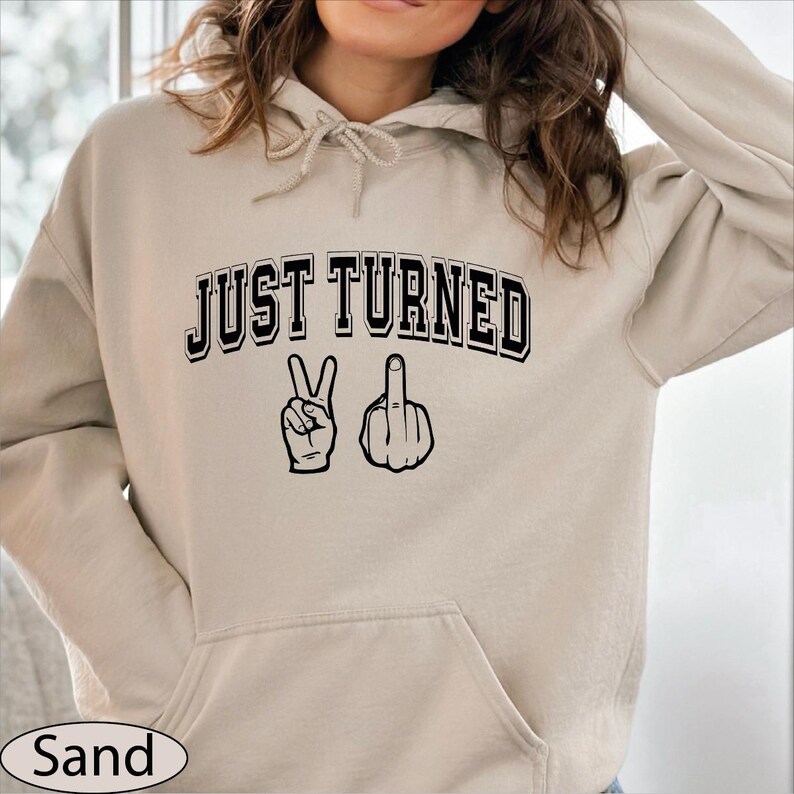 a woman wearing a hoodie that says just turned