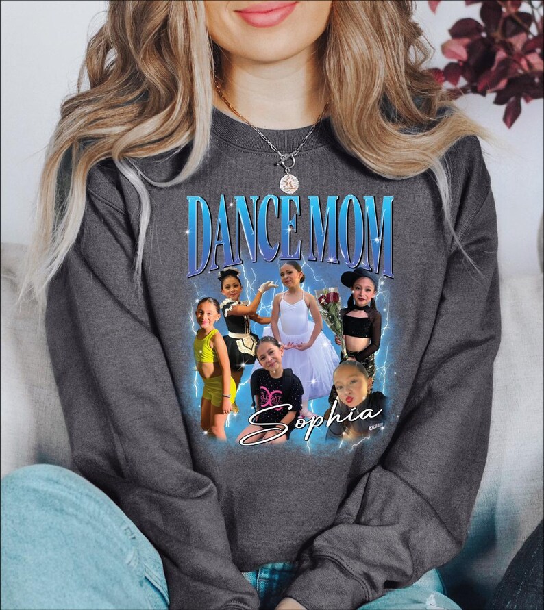 a woman sitting on a couch wearing a dance mom sweatshirt