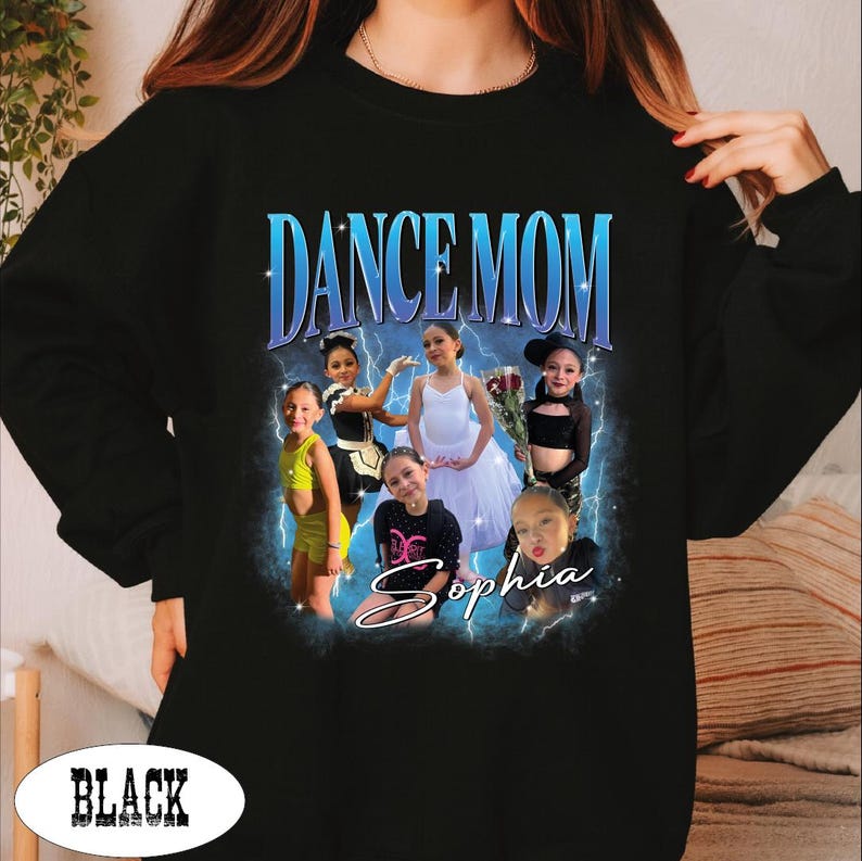 May include: Black sweatshirt with a graphic that says "DANCE MOM" in blue text. The graphic features photos of young dancers and the name "Sophia". The sweatshirt is black.