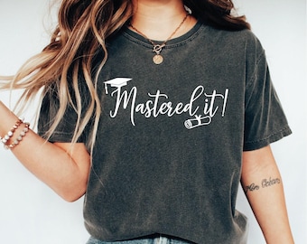 May include: A dark gray t-shirt with a white graphic that says "Mastered it!" with a graduation cap and diploma scroll.