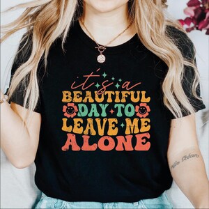 a woman wearing a t - shirt that says, it's a beautiful day