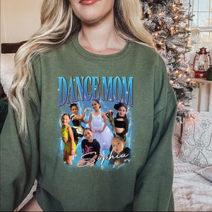 a woman wearing a green sweatshirt with pictures of dancers on it