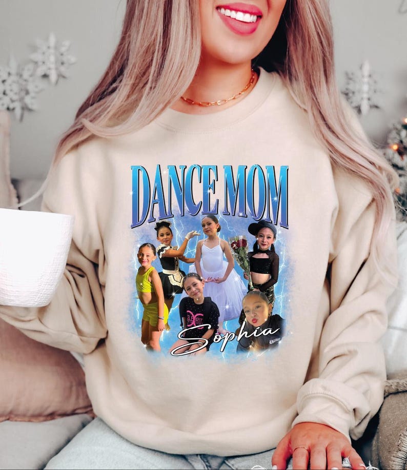 a woman sitting on a couch wearing a dance mom sweatshirt