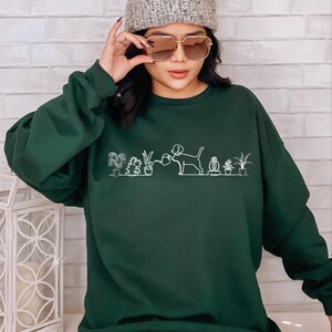 a woman wearing a green sweatshirt and a beanie